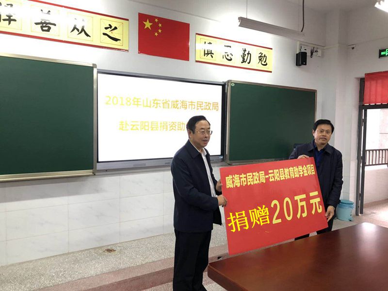 1、威海市民政局党委书记、局长（左）栾波向云阳县教育局转交20万元助学款。王明源摄.jpg